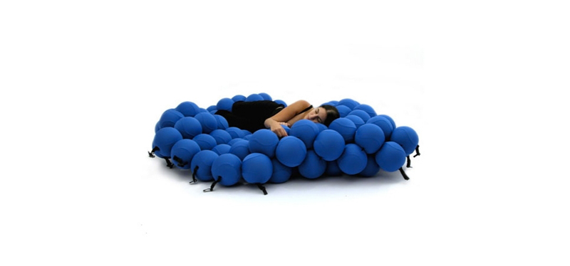 A woman sleeping on a blue Feel Seating Deluxe by Animi Causa