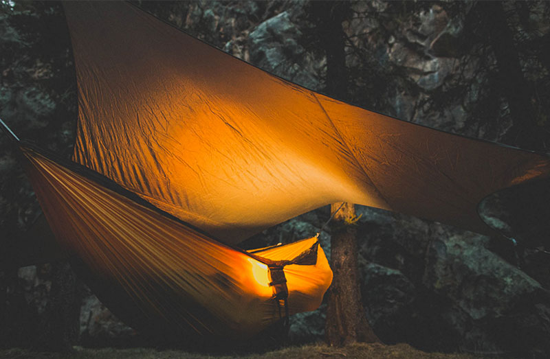 Kammok Glider Rain Tarp and Hammock Weather Relief Shelter set up at night in the forest