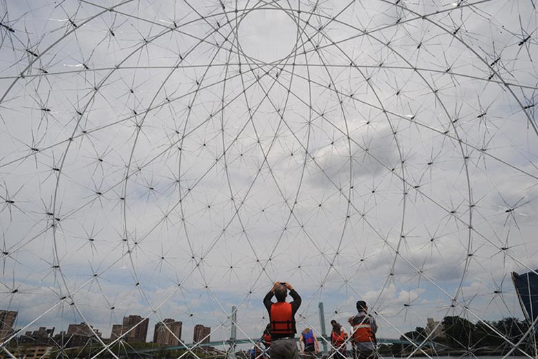 Floating Dome made of discarded umbrellas and plastic bottles by SLO Architecture placed in the Bronx River in New York 