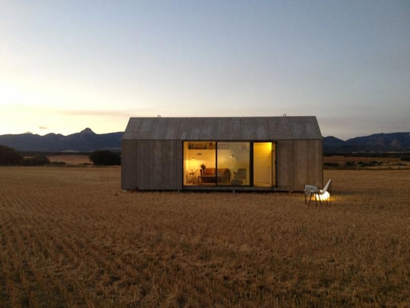 aph80 Portable Concrete Prefab House by Abaton placed in a field