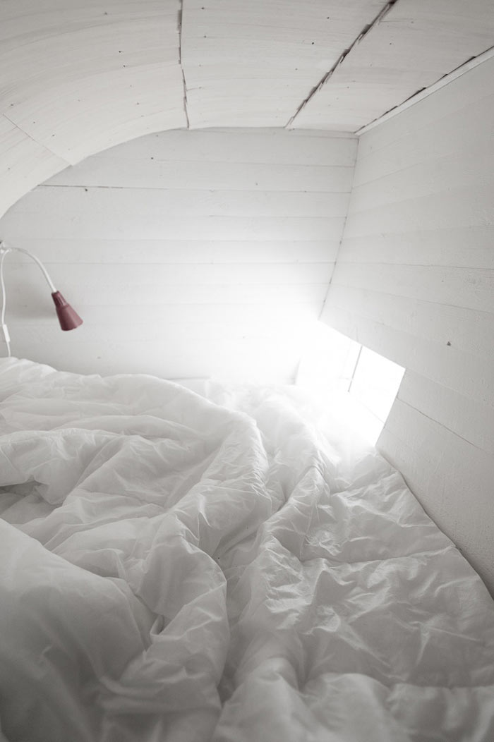 Interior decor and white bed sheets at the Curved Hus-1 by Torsten Ottesjo Architecture