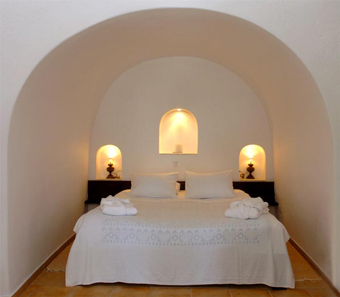 Bed in bedroom at the Ikies Traditional Houses in Santorini