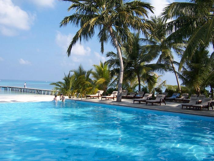 Swimming pool and palm trees at Club Med Kani Family Resort in The Maldives