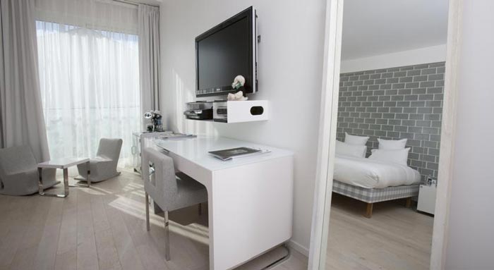White table and flatscreen TV in a hotel room in Saint-Tropez
