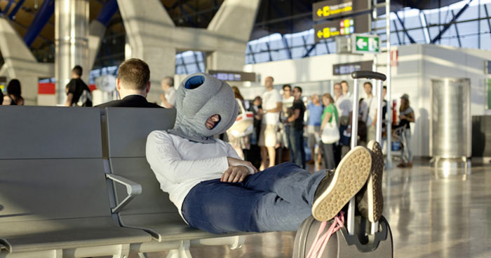 Man using the Ostrich Pillow at the airport