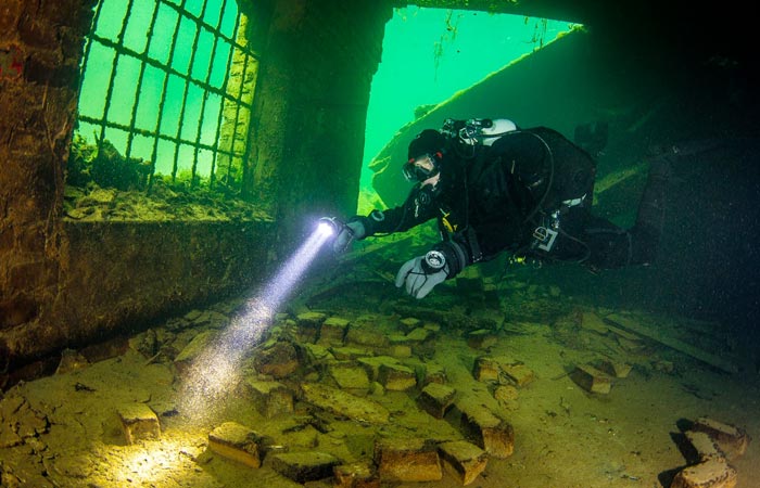 Scuba diver inside Rummu underwater prison