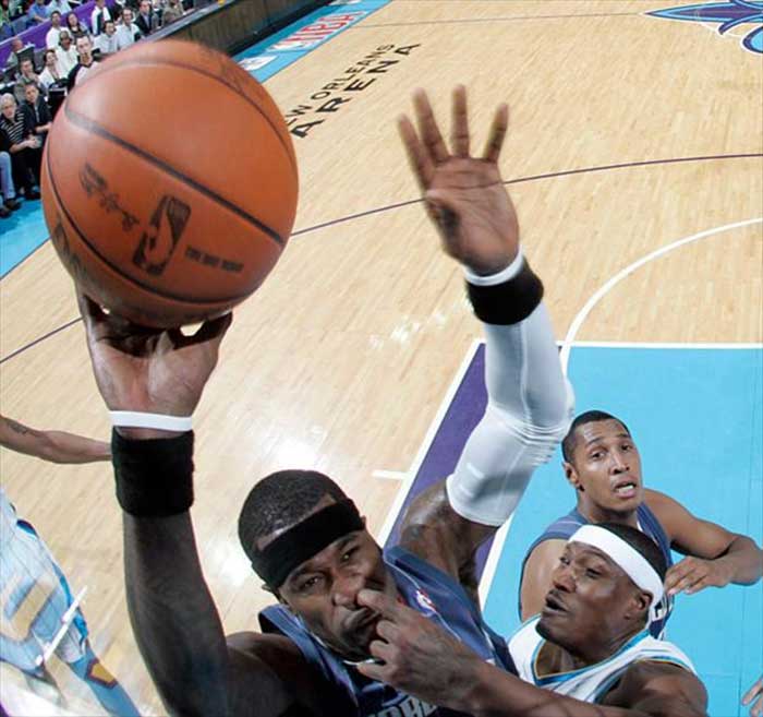 A basketball player picking other basketball player's nose