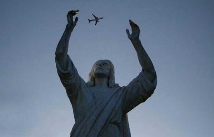An airplane between monument's hands