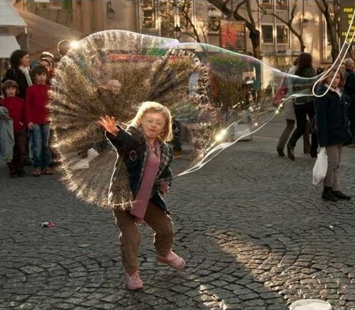 A boy puncturing a bubble balloon 