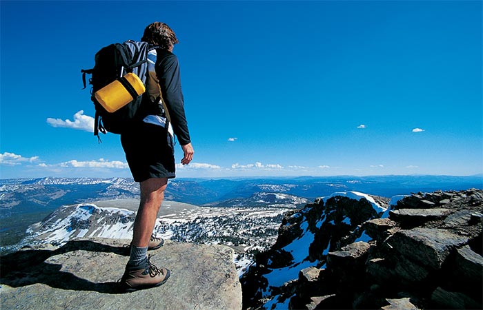 A guy backpacking, standing at a cliff