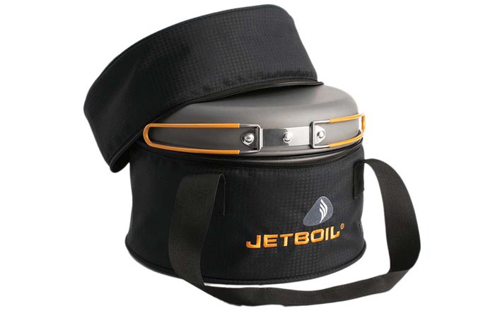 Jetboil Genesis Base Camp Stove, packed in a slightly open black carry bag, on a white background.