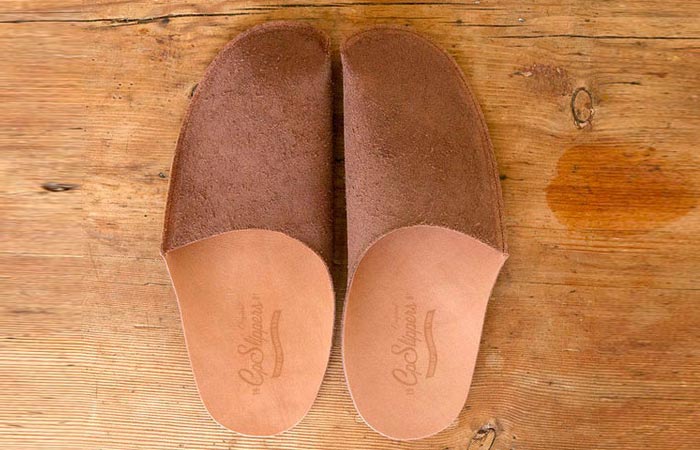 Luxurious Leather Slippers, brown, on a wooden surface.
