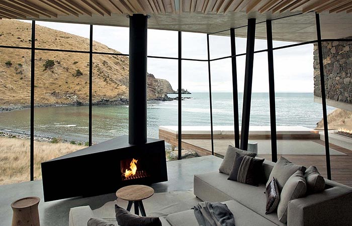 Seascape Retreat on a South Pacific Cove, interior, living room with a sofa and a fireplace, with a beach view.
