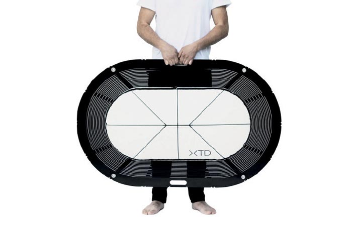 XTEND Portable Bathtub, packed for transportation, a figure of a man holding it in front of his body. White background.