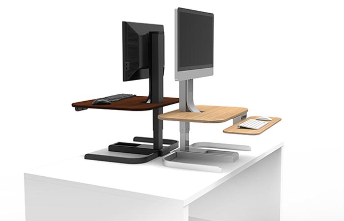 Crossover Motorized Standing Desks, brown and tan, on a white deck, with monitors on it, facing opposite directions, on a white background.
