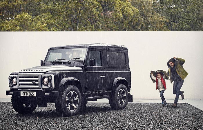 Defender captured from the distance alongside with some people on the rain. 