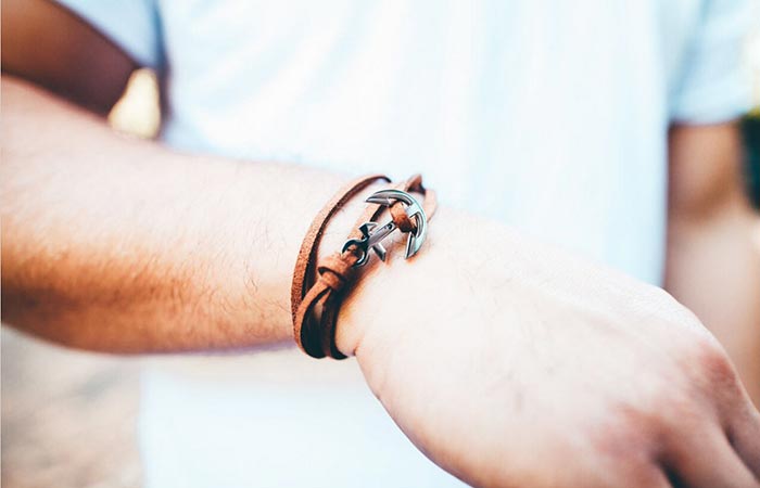 Thread Etiquette Chestnut Leather Anchor Bracelet on the hand of a man in white tee shirt.