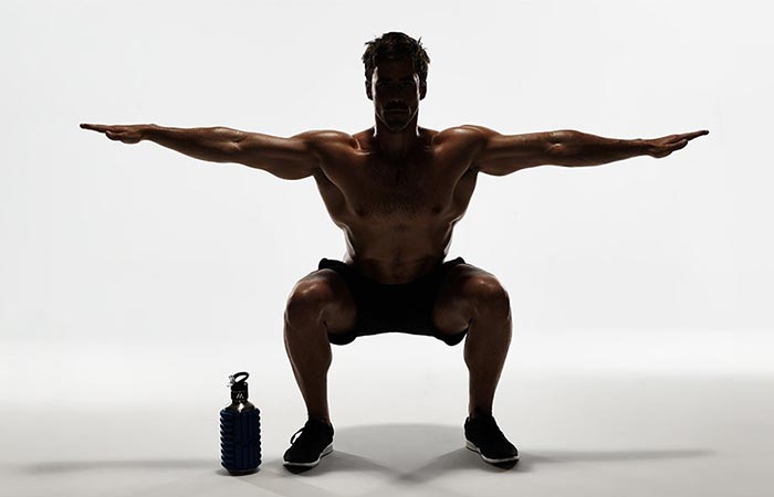 A Guy Excercising With Mobot Water Bottle & Roller Next To Him