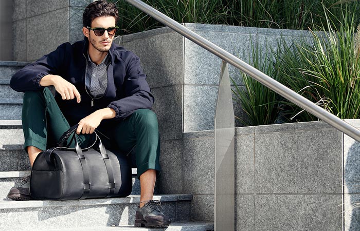 A Guy Sitting On A Staicase With A Troubadour Day Bag