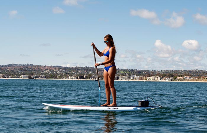 Woman using the Bixpy Swim Jet on her paddle board