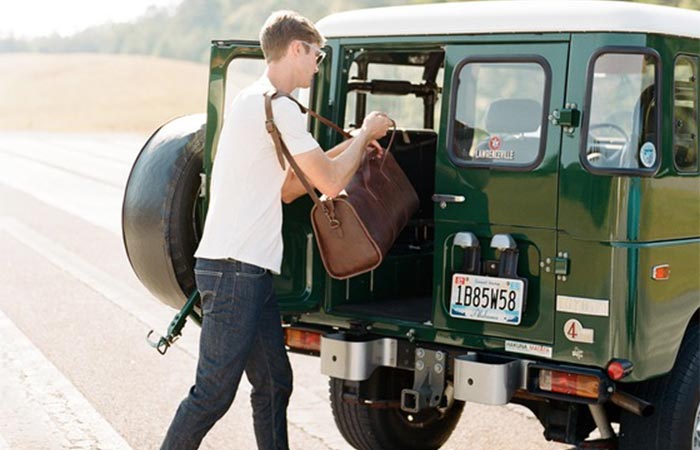 Man putting the Leon Weekender into his jeep.