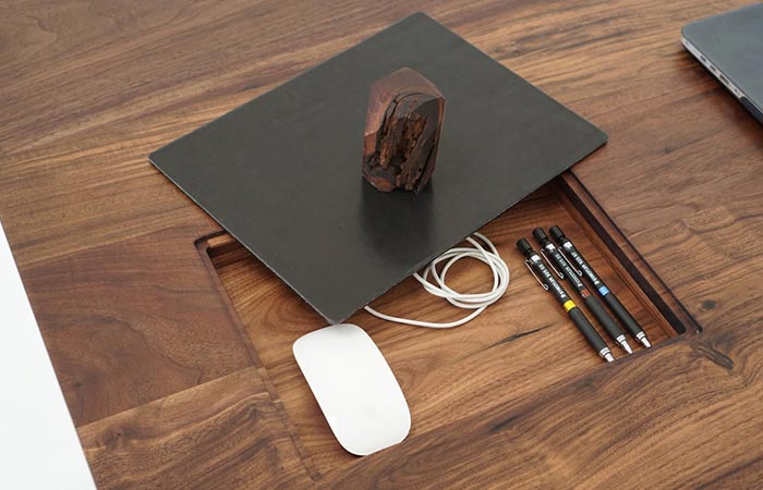 a mouse pad and a small opening in the desk