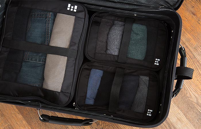 a suitcase with three compression bags inside