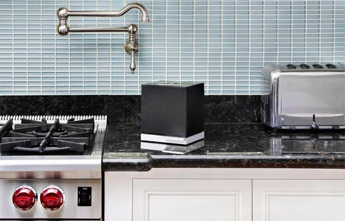 small black cube speaker on the kitchen counter