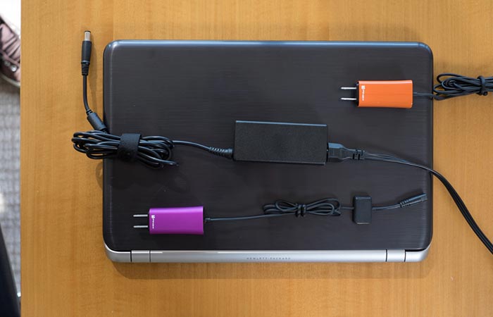 FINsix Dart-C in two colors next to an original laptop charger