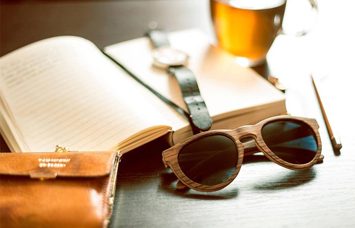 wooden glasses next to a book, watch and beer glass