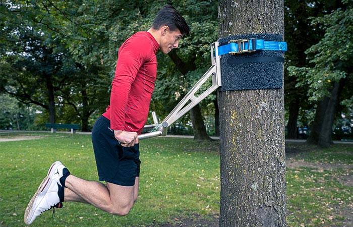 Man using the Pullup & Dip outside on a tree