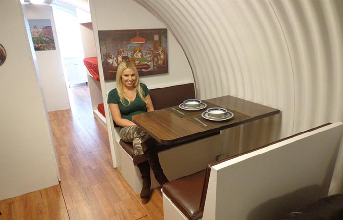 Girl sitting at a dining room table inside an Atlas Survival Shelter