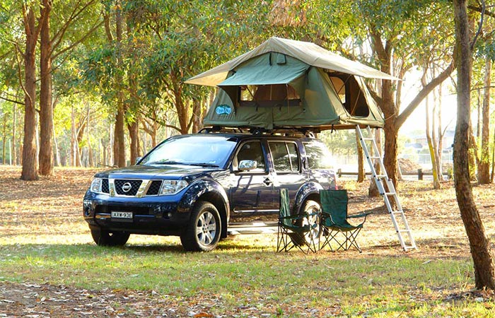 a nissan car with a rooftop tent on it