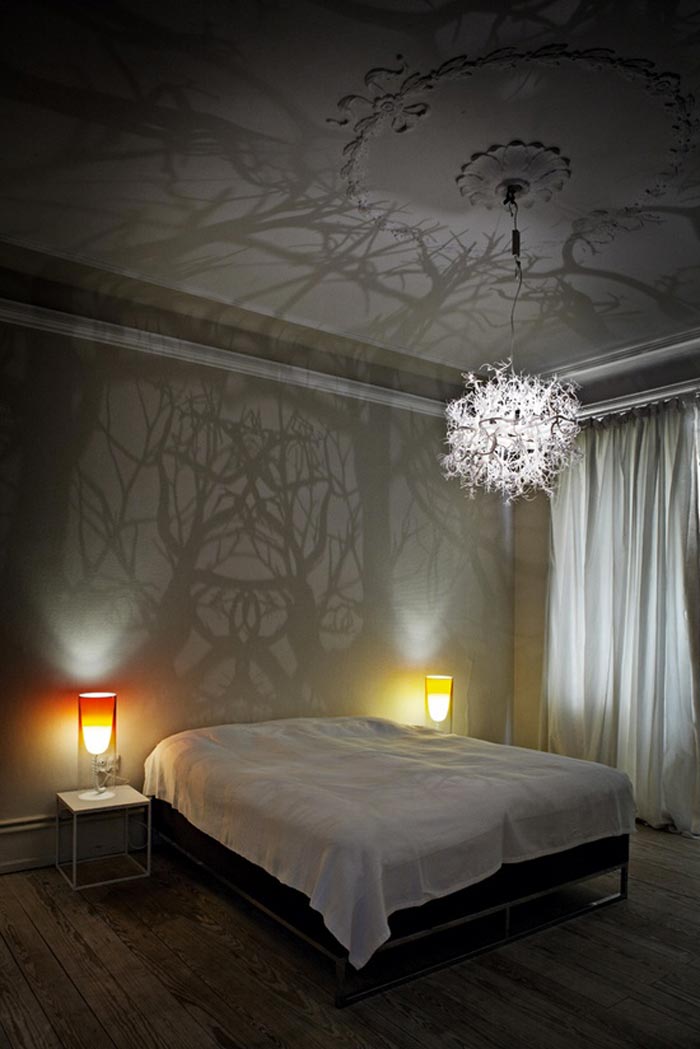 Light sculpture projecting tree shadows on the walls of a bedroom