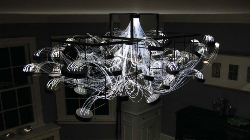Bacterioptica Chandelier designed by Mad Lab attached to the ceiling in a dining room