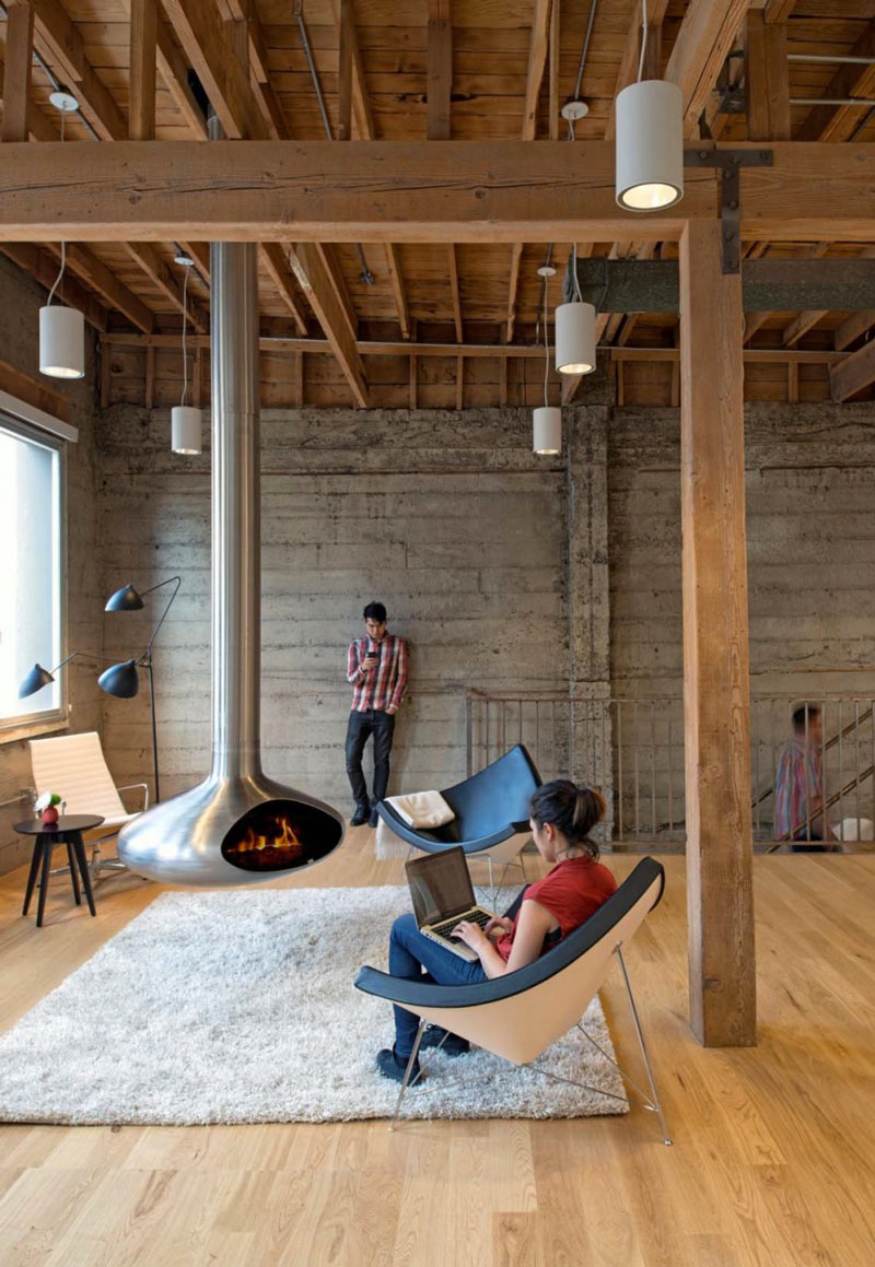 Employees around the fireplace and chimney in the center of a room at Giant Pixel Headquarters in San Francisco designed by Studio O+A