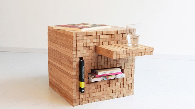 Books and a glass of water stored on the side of the Pixel Table designed by Studio Intussen