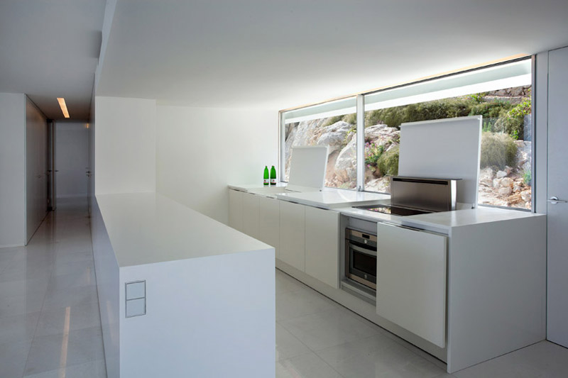Interior design of the kitchen and window at the House on the Cliff by Fran Silvestre Arquitectos