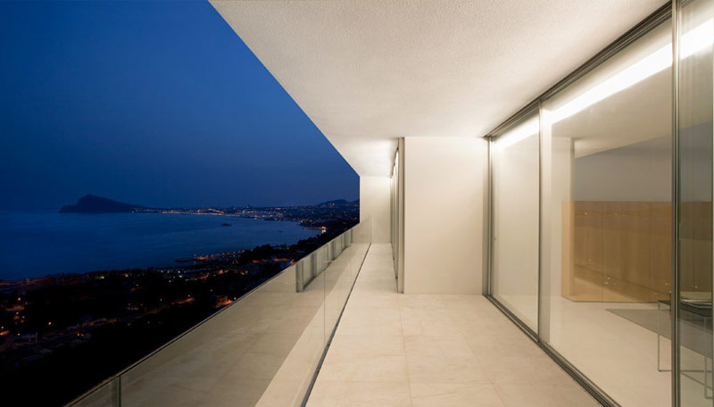 exterior patio and glass door of the House on the Cliff by Fran Silvestre Arquitectos