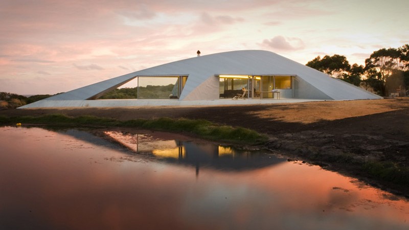 Exterior view of the architecture at the Crofthouse by James Stockwell by the lake during a sunset