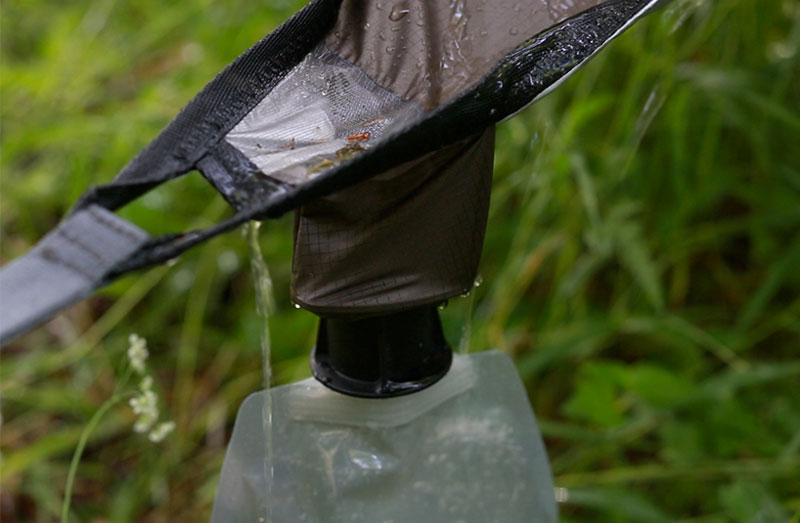 Water being collected in a bottle on the edge of the Kammok Glider Rain Tarp and Weather Relief Shelter
