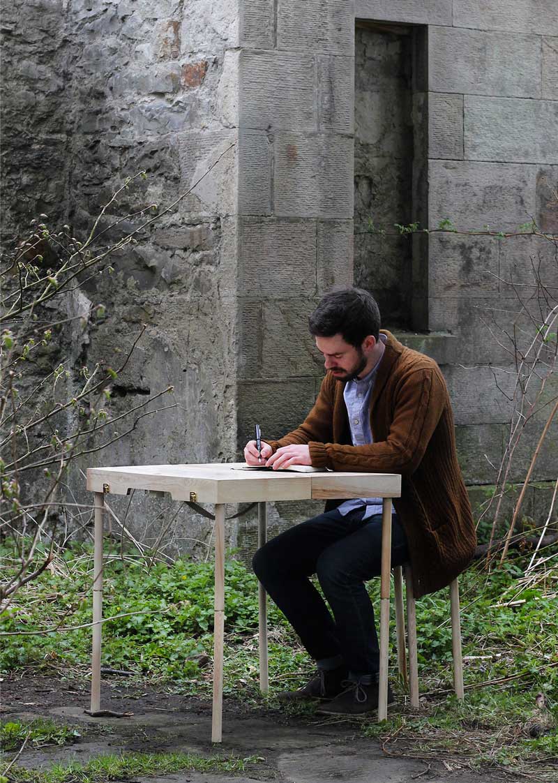 Man using the BOXED Multi Functional Furniture by Tyrone Stoddart as a desk outdoors
