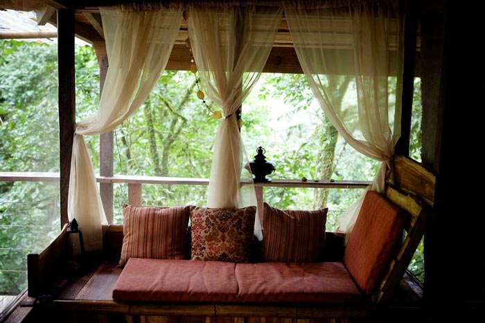 Couch with red pillows at the Finca Bellavista Treehouse Community in Costa Rica