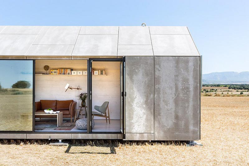 Side view with the panels open of the aph80 Portable Concrete Prefab House by Abaton