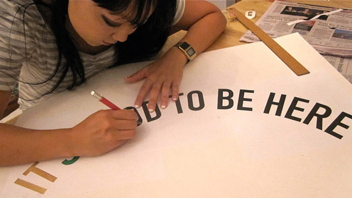 Candy Chang drawing the outline of 'It's Good to be Here'
