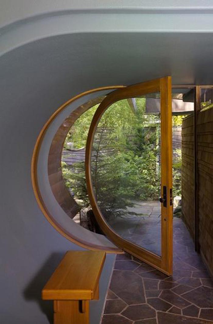 Rounded wooden and glass door at a Treehouse Mansion in Portland, Oregon by Robert Harvey Oshatz