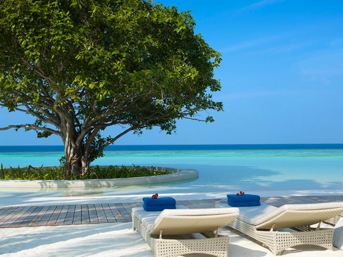 Lounge chairs and the sea at Dusit Thani Maldives Resort in Baa Atoll