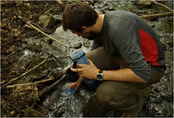 Man using the Lifesaver Bottle - A Portable Water Filter System to purify unclean water