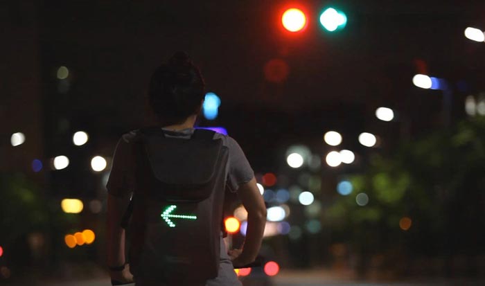 Cyclist using the SEIL Bag - An LED Backpack for Cyclists at night