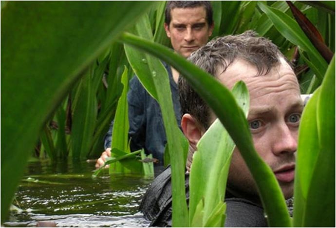Men walking in shoulder high water during the Bear Grylls Survival Academy